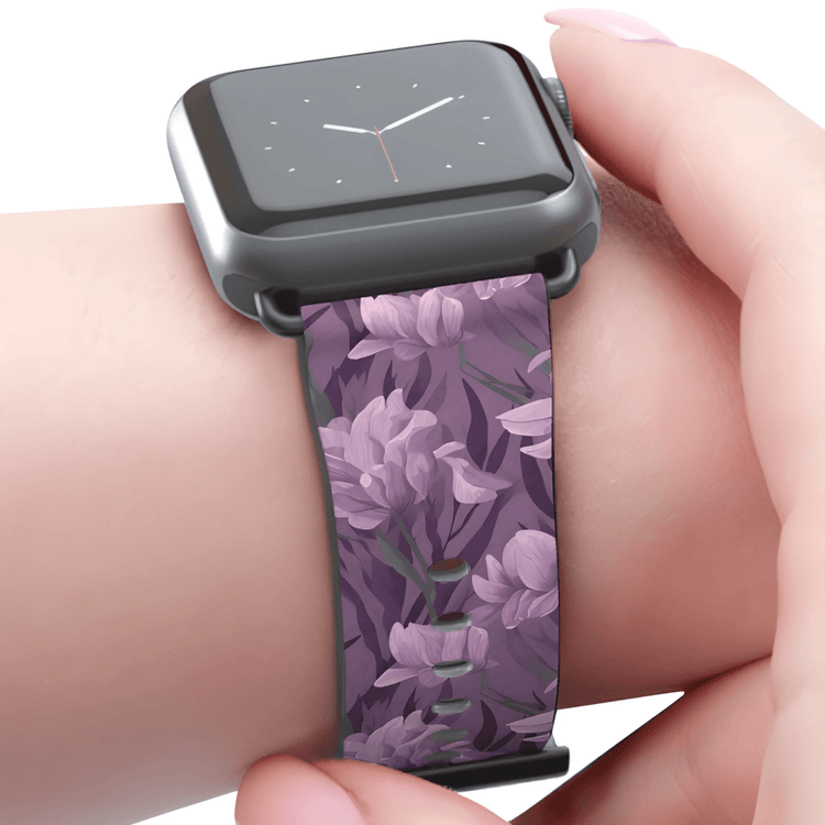 An Apple Watch with a purple and pink floral strap with a dark purple background.