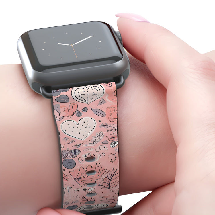 A pattern showcasing hearts and spring flowers in a pink and slate theme printed onto an apple watch wrist strap.